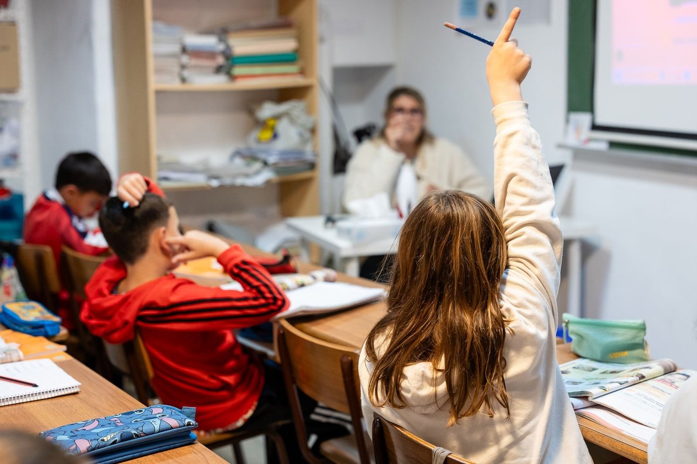 Una alumna de Lenguasol levanta el brazo para opinar en clase